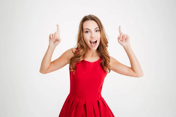 Mulher de vestido apontando os dedos para cima e olhando para a câmera — Fotografia de Stock