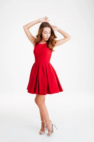 Mulher morena bonita em vestido vermelho posando com as mãos levantadas — Fotografia de Stock
