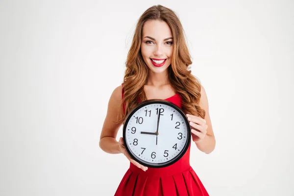 Žena v červených šatech santa claus drží nástěnné hodiny — Stock fotografie