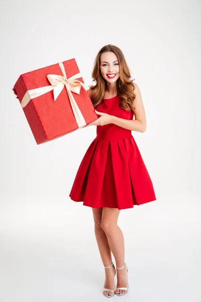 Щаслива жінка в червоній сукні тримає подарункову коробку — стокове фото