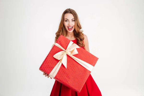 Mulher em santa claus vestido dando-lhe grande presente vermelho — Fotografia de Stock