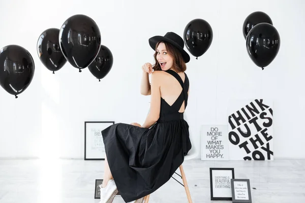 Mujer sentada con globos negros y carteles sobre fondo blanco —  Fotos de Stock