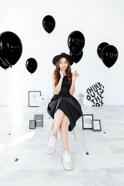 Smiling pretty young woman with black balloons and posters — Stock Photo, Image