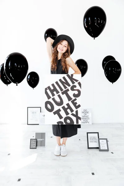 海报和黑色气球开朗可爱的年轻女子 — 图库照片