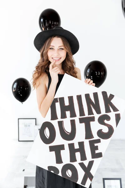 Sonriente linda joven con globos negros y pizarra blanca —  Fotos de Stock