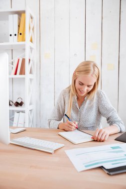 Genç iş kadını notlar onun işyerinde otururken yapma