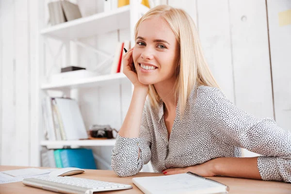 Bizneswoman siedzi w miejscu pracy i robi notatki — Zdjęcie stockowe