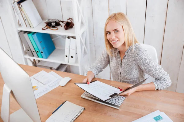 Business woman holding opened folder and looking at camera — Stock Photo, Image
