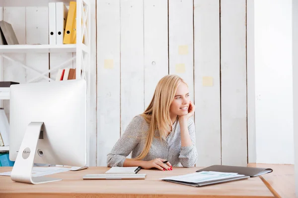 Leende business kvinna sitter vid bordet och tittar bort — Stockfoto