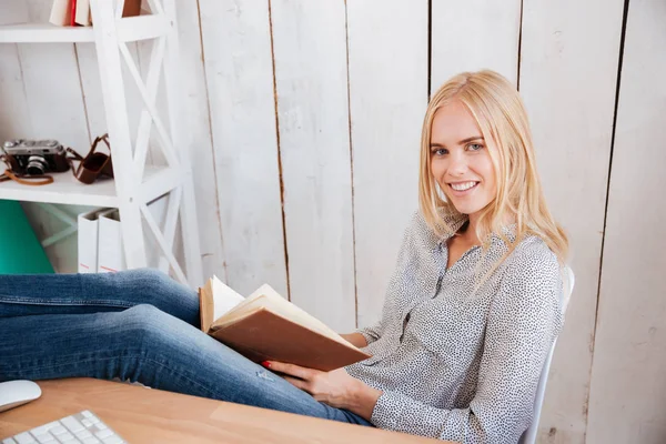 Kobieta kobieta interesu, czytanie książki, siedząc w miejscu pracy w biurze — Zdjęcie stockowe