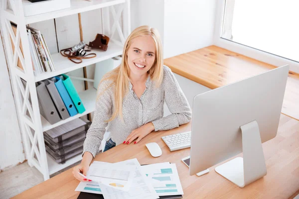 Mujer trabajando con papeles e informática en la oficina — Foto de Stock