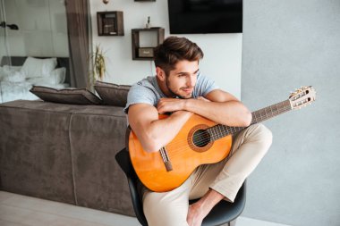 Gitar sandalye üzerinde oturan genç adam
