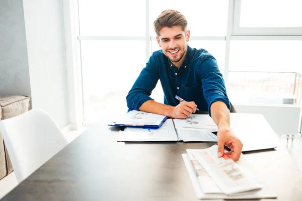 Ung man analysera finanser och hålla tidningen — Stockfoto