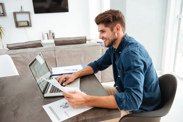 Joven feliz analizando sus finanzas caseras — Foto de Stock