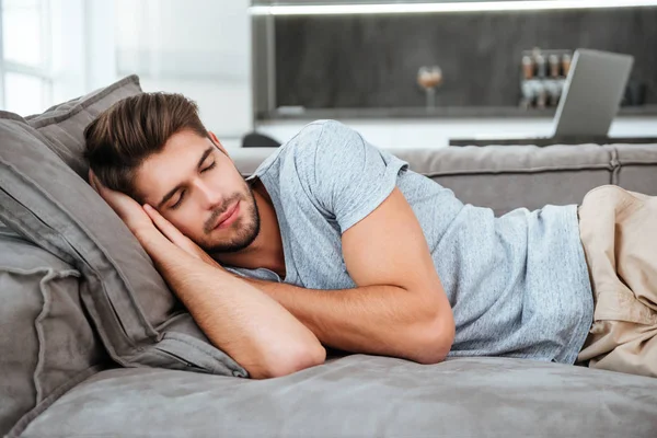 Müder Mann schläft auf einem Sofa — Stockfoto