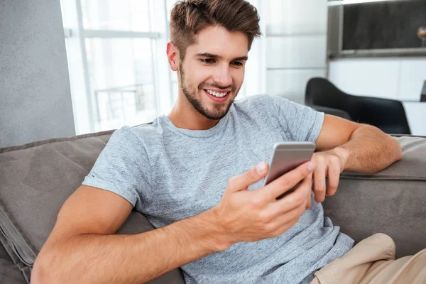 Jovem alegre jaz no sofá e conversando — Fotografia de Stock