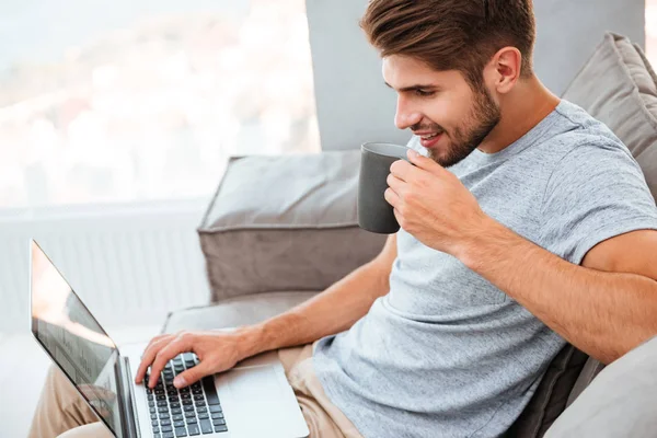 Gelukkig man die op laptop werkt en een kopje koffie drinken — Stockfoto