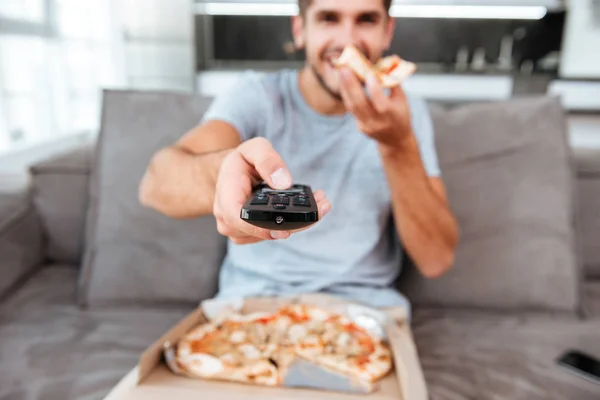 Man pushing button on remote control — Stock Photo, Image