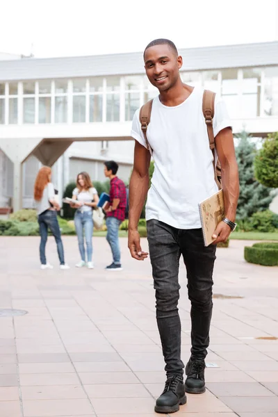Estudante homem africano feliz com mochila andando ao ar livre — Fotografia de Stock