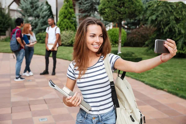 Šťastná mladá žena studenta, který selfie s mobilní telefon venku — Stock fotografie