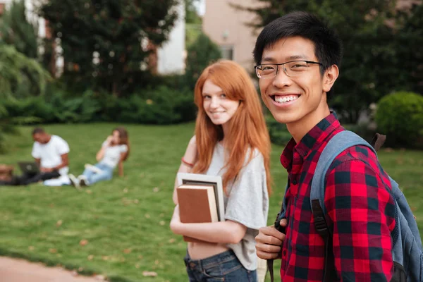 Asya genç adam öğrenci kız arkadaşı ile açık havada yürüyüş gülümseyen — Stok fotoğraf
