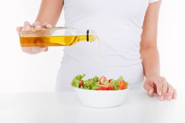 Genç kadının pişirme sebze ve yağ ile Resim kırpılmış