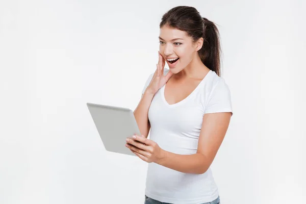 Joven mujer sorprendida sosteniendo tableta digital — Foto de Stock