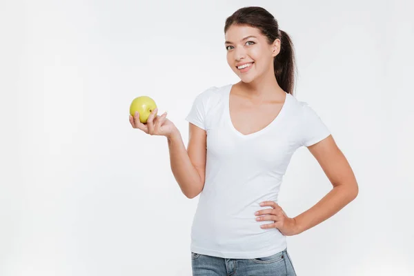 Cheerful woman holding apple over white background — Stock Photo, Image