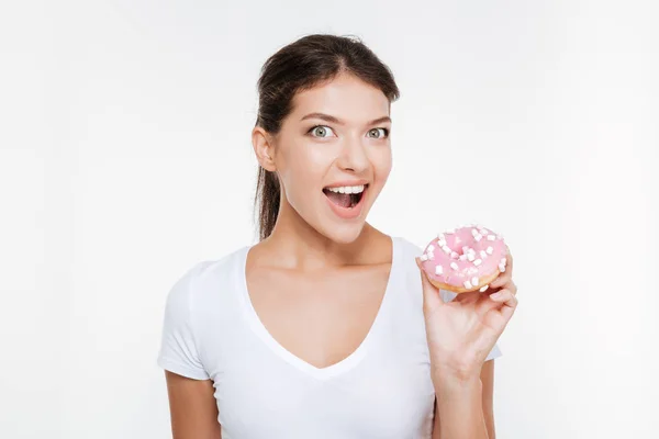 Rolig ung kvinna äta välsmakande donut på vit bakgrund — Stockfoto