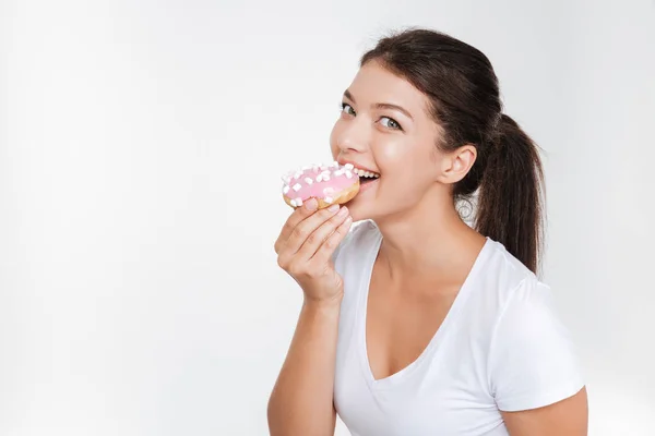 Söt ung kvinna äta välsmakande donut — Stockfoto