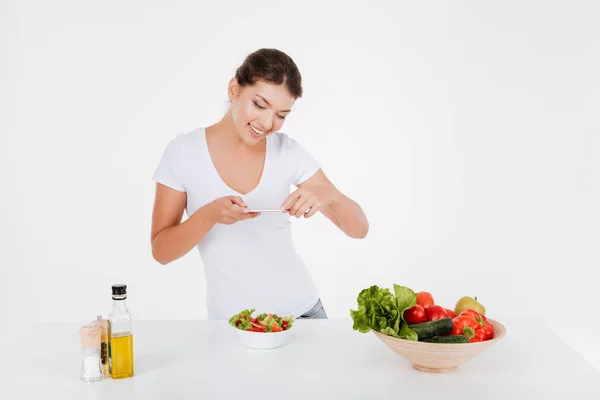 Menina bonito tirar foto de salada de legumes no telefone — Fotografia de Stock