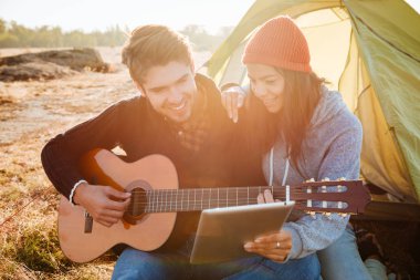 Mutlu çift gitar ile çadır yakınındaki
