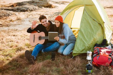 Çift gitar çadırın yakınında ile gülümseyen