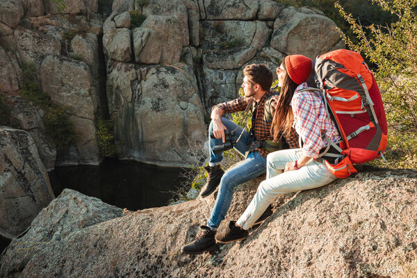 Adventure couple sitting on a rock