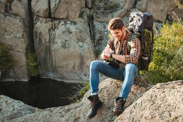 Tourist man sitting on rock — Stock Photo, Image