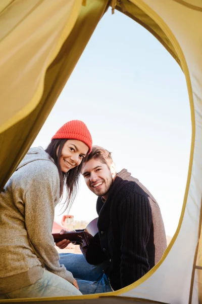 Happy young couple in love sitting together at camping tent. — Stock Photo, Image