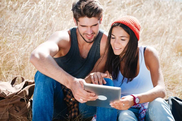 デジタル タブレットを使用してのキャンプ旅行に若いカップルの笑顔 — ストック写真