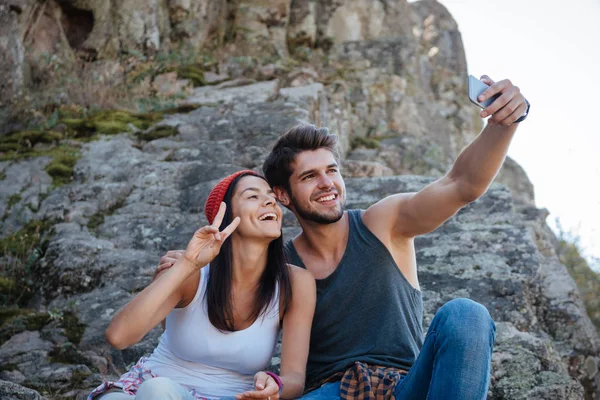 Lächelndes Paar macht Selfie auf Felsen — Stockfoto