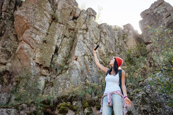 Молодая путешествующая женщина возле скалы — стоковое фото
