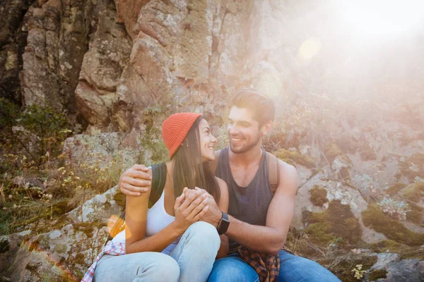 Pareja feliz sentada en roca — Foto de Stock