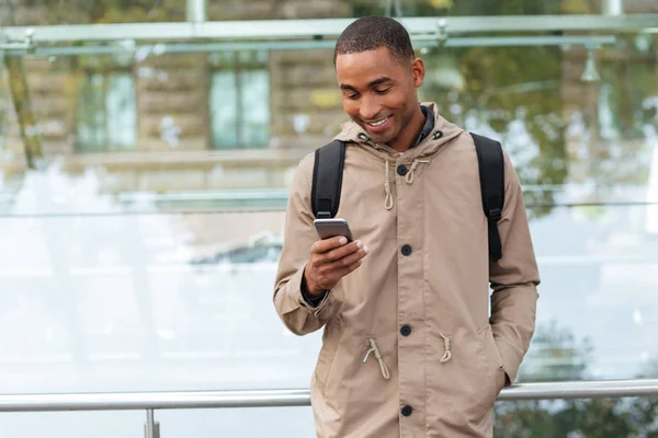 Happy young african man chatting outdoors — Stock Photo, Image