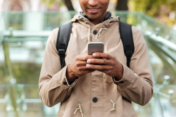 Cropped photo of cheerful dark skinned man using cellphone — Stock Photo, Image