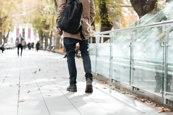 Cropped photo of young african walking man along a street