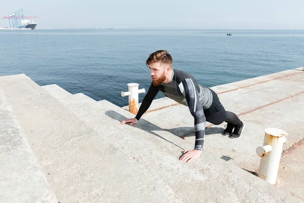 Homme faisant push ups près de la mer — Photo