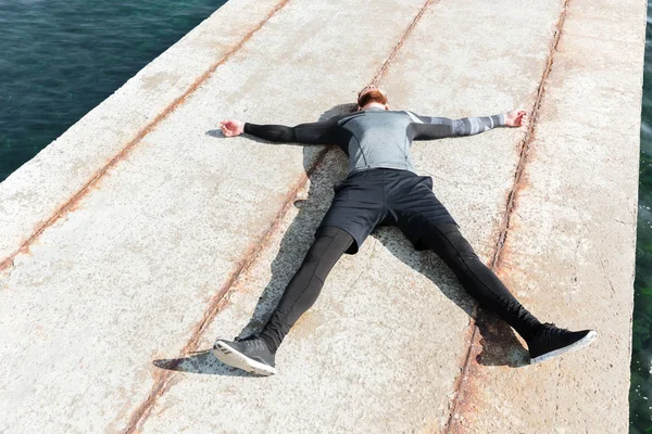 Uomo sdraiato sul molo — Foto Stock