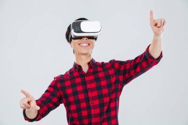 Sanal gerçeklik aygıt giyen ve gösteren Asyalı adam