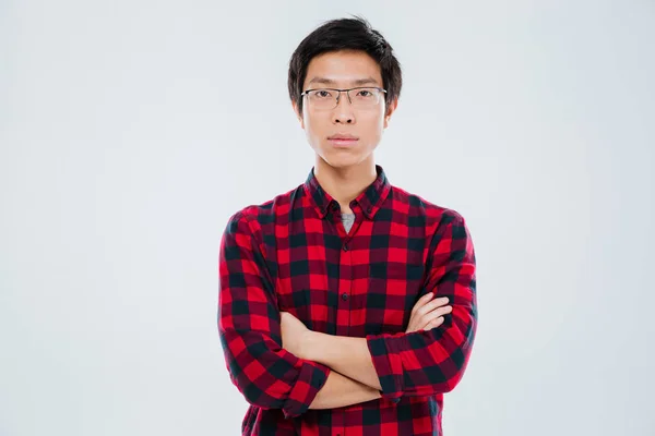 Young man in casual shirt standing with arms crossed — Stock Photo, Image