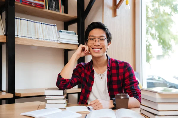 Asian Mężczyzna siedzący z książek w bibliotece — Zdjęcie stockowe