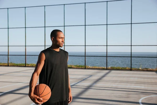 Serius afro american olahragawan memegang basket dan berpaling — Stok Foto