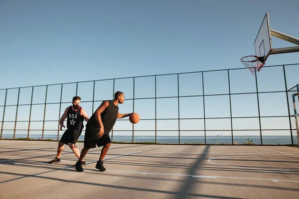 Retrato de dois desportistas jogando basquete no parque infantil ao ar livre — Fotografia de Stock